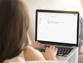 Eine junge Dame schreibt eine E-Mail am Notebook