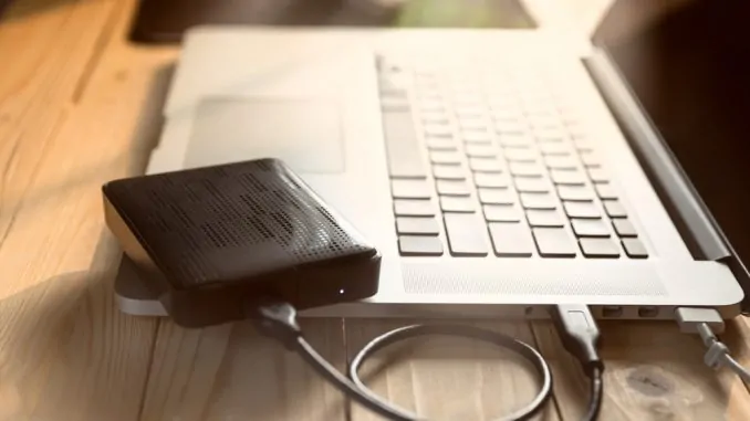 Eine externe Festplatte, die an einem Notebook angeschlossen ist.