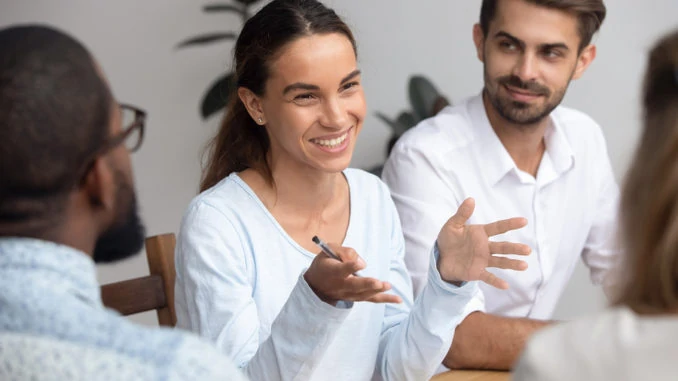 Glücklicher Frauenführertrainermentor, der mit Angestellten bei der Sitzung spricht