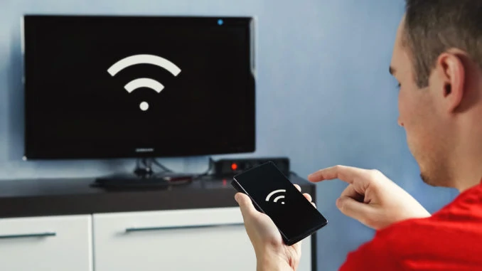 Konnektivität zwischen Smart-TV und Smartphone über WLAN-Verbindung. Steuern Sie Ihren Fernseher mit Ihrem Smartphone. Das WLAN-Symbol auf dem Telefonbildschirm und dem Monitor