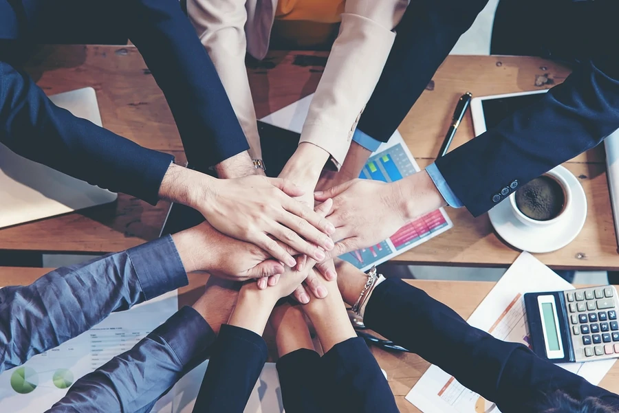 Teamwork Erfolg. Draufsichtexekutivgeschäftsleute gruppieren das Team, das glücklich ist, Teamwork zeigend und sich Händen anschließend, nachdem sie Partnergeschäft im Büro getroffen haben. Unternehmenskonzept.