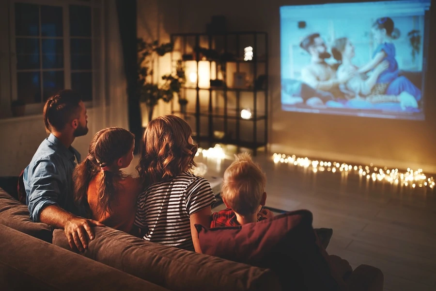 familie mutter vater und kinder schauen projektor, fernsehen, filme mit popcorn am abend zu hause