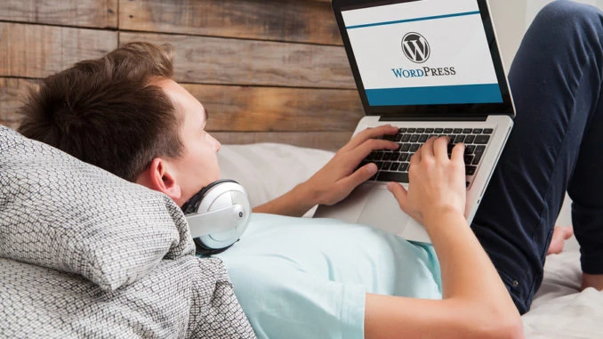 WordPress-Markenlogo auf dem Computerbildschirm. Mann, der auf der Tastatur tippt. WordPress ist ein kostenloses Open-Source-Blogging-Tool und ein Content-Management-System (CMS).