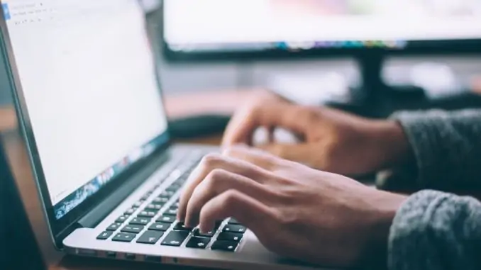 Business Mann sitzt vor dem Laptop