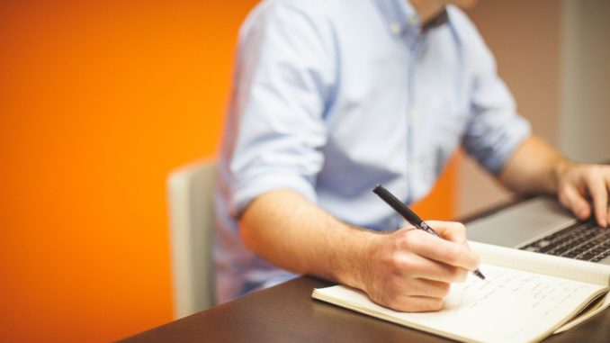 Büromitarbeiter sitzt am Tisch