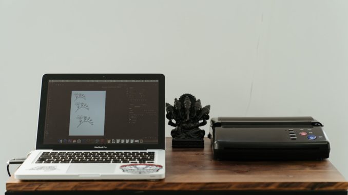 Laptop und Drucker stehen auf Tisch